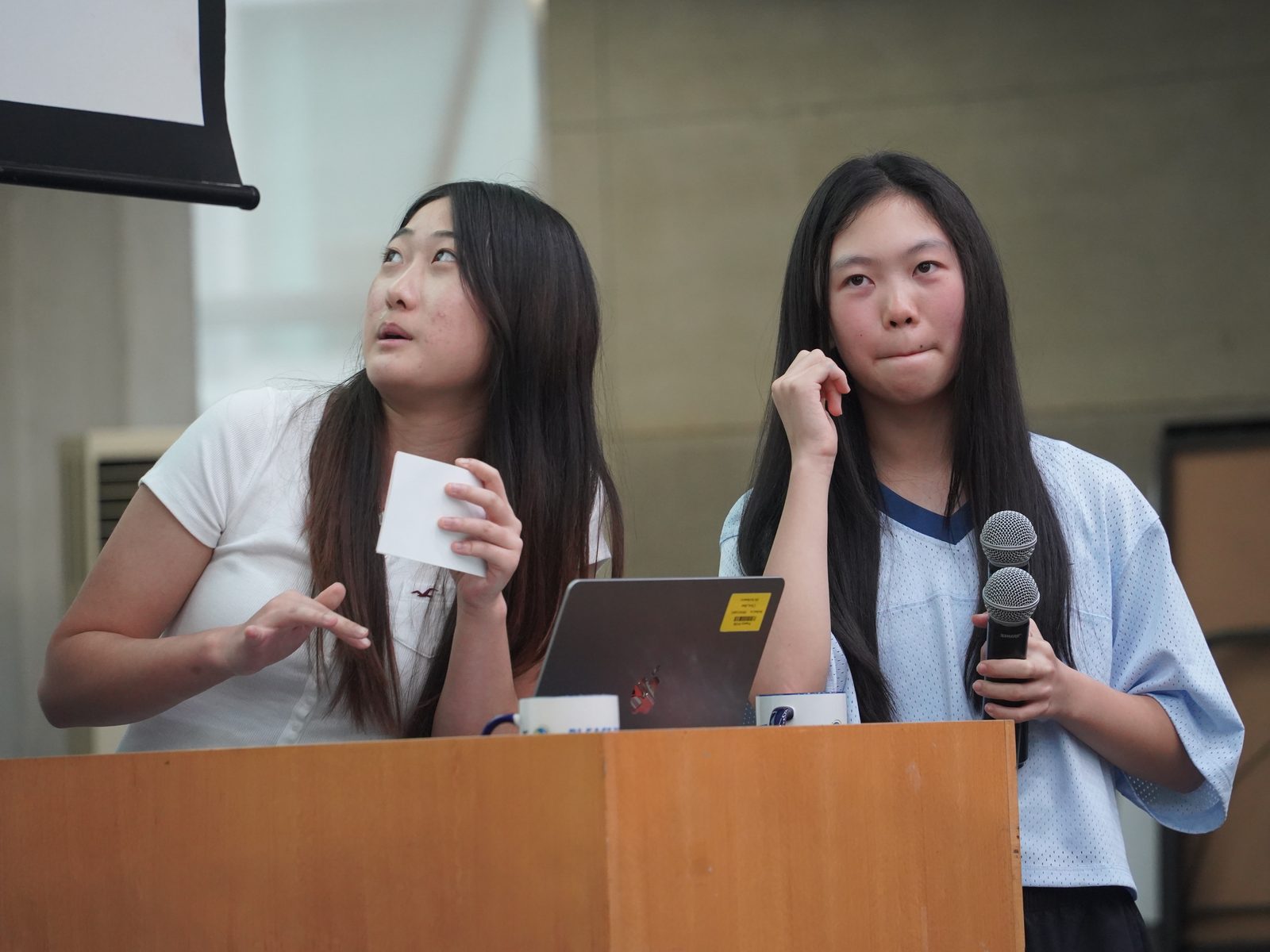 两名学生在讲台前回答提问